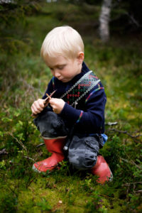 Pojke med knivbälte i skogen